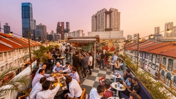 日落时分，Potato Head Singapore 的宾客在用餐、聊天和交谈