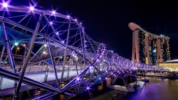 夜晚的 DNA 形螺旋桥分外迷人，背景为滨海湾金沙® 