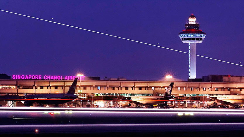 樟宜机场跑道上的飞机，背景是控制塔