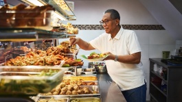 甘榜格南 Warong Nasi Pariaman Nasi Padang 的店主正在准备食物