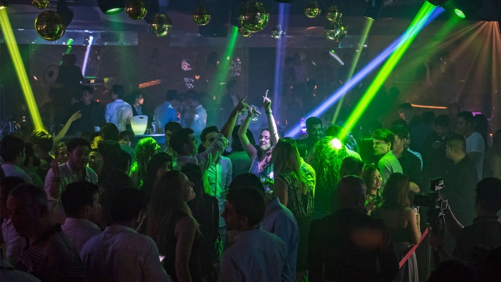 派对爱好者在 Zouk 夜店的迷离绿光中起舞