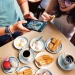 一群人在享用新加坡传统早餐——咖椰土司、kopi（咖啡）和半生熟鸡蛋