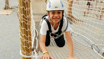 孩子开心地在冒险乐园 Forest Adventure 体验障碍训练场
