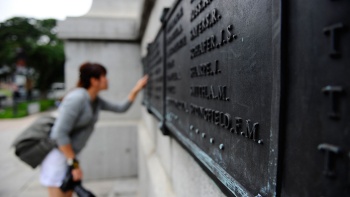 一名游客在世界大战阵亡战士纪念碑前阅读阵亡将士的铭文