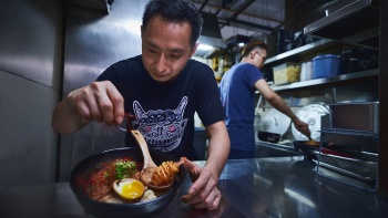 超好面的两位主厨正在制作荣登米其林 “必比登推介” 榜单的面食，将日式拉面与虾、叉烧和饺子搭配。
