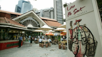 Exterior shot of people dining and the signage of Lau Pa Sat