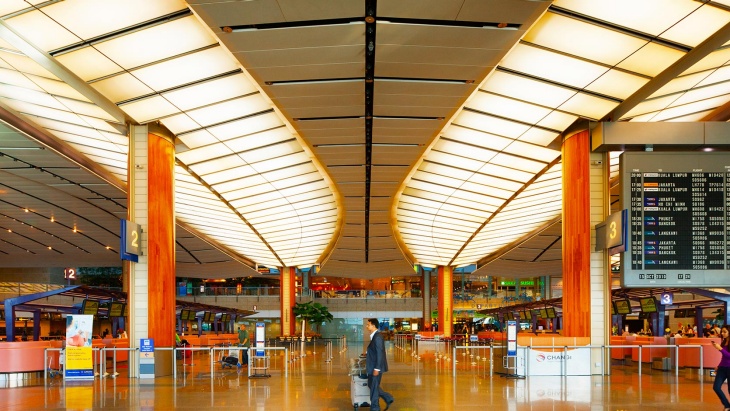 在新加坡樟宜机场 2 号航站楼推着行李的旅客