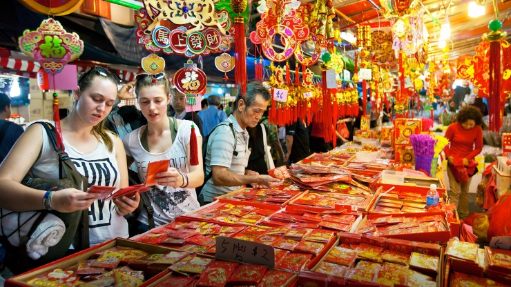 Wide shot of tourists buying red packets at Chinatown