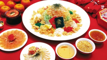 新马一带农历新年的特色菜 “捞鱼生”（粤式生鱼片沙拉，也称 “lou hei”，粤语发音的 “捞起” 之意）