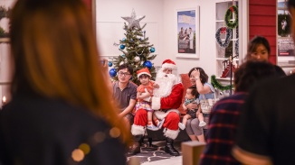 一家人在拍照亭中与圣诞老人合影。