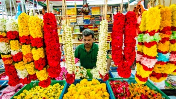 一位售卖鲜花和花环的男子特写照。