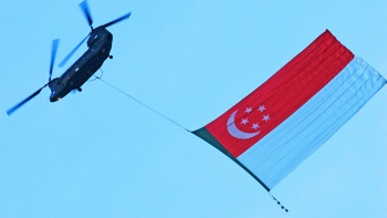 新加坡空军部队直升机拉着国旗划空飞行而过