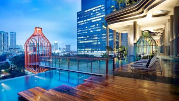从皮克林宾乐雅酒店的无边泳池和池畔凉棚俯瞰新加坡的天际线。