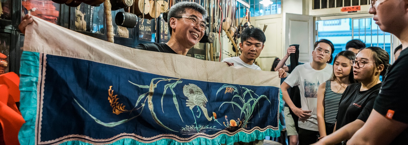翁展发老绣庄的工作人员拿着红彩，展示中国传统的刺绣文化 