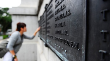 参观者认真端详世界大战阵亡战士纪念碑上记录着的阵亡战士名单
