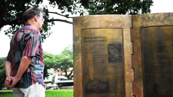 一名游客正在印度国民军纪念碑前阅读碑文