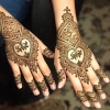 Hands decorated with henna patterns by SyraSkins henna studio.