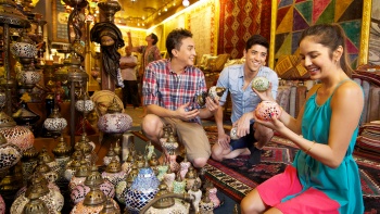 Friends souvenir shopping in a store along Arab Street