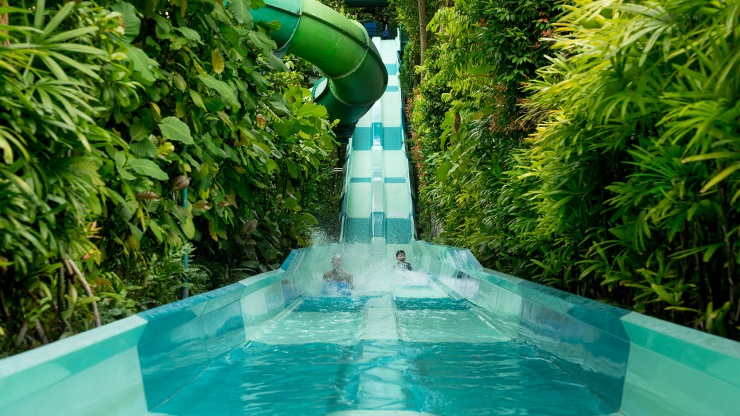 孩子们在圣淘沙名胜世界 (Resorts World™ Sentosa) 水上探险乐园玩水滑道