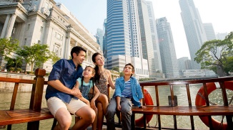 一家人在驳船上欣赏白天的新加坡天际线