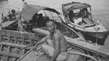 20 世纪三十年代至五十年代期间，一位华人劳工在海边对着镜头拍照 