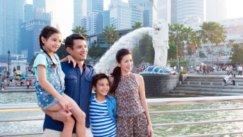 A young Eurasian family posing for a photo at Merlion Park 