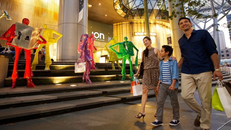 一家人手持购物袋、在爱雍·乌节购物中心逛街