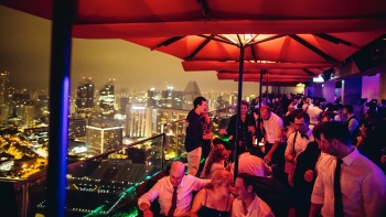 夜幕中， Ce La Vi 餐馆和空中酒吧内人们开心地饮着酒